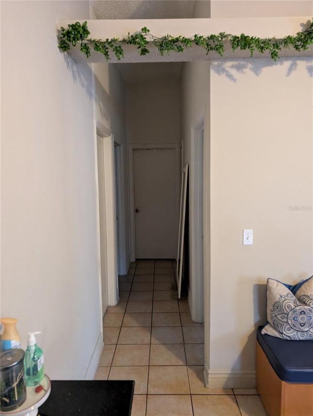 hallway with baseboards and light tile patterned flooring