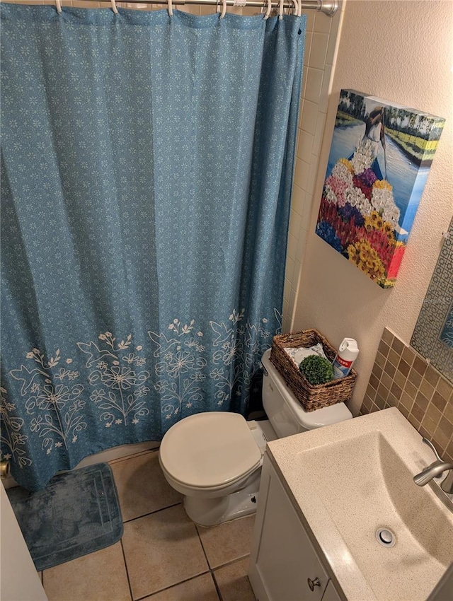 bathroom featuring toilet, a textured wall, vanity, and tile patterned floors