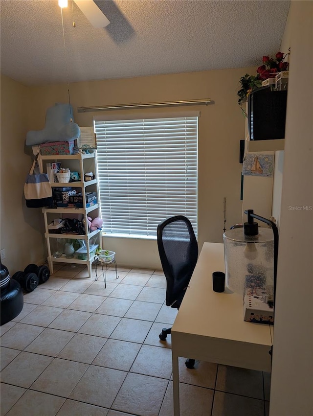 office space with light tile patterned floors, ceiling fan, and a textured ceiling