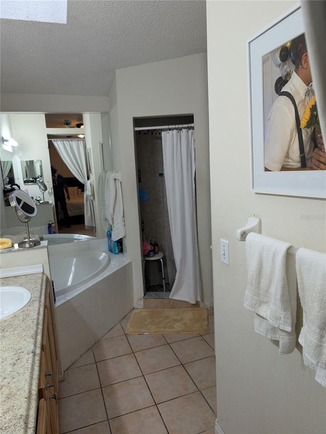 bathroom with a stall shower, tile patterned flooring, a textured ceiling, vanity, and a bath