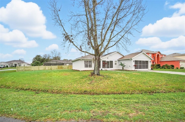 view of front of house featuring a garage, fence, driveway, stucco siding, and a front lawn