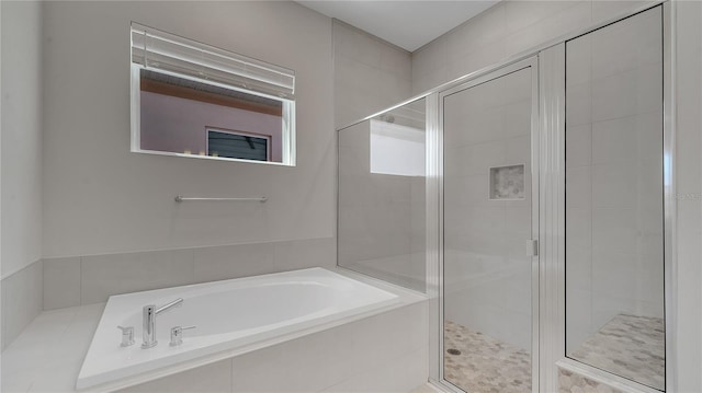 bathroom with a bath and a stall shower