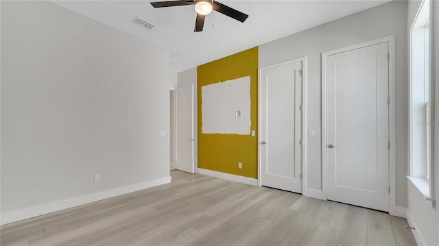 unfurnished bedroom with visible vents, baseboards, ceiling fan, and light wood finished floors