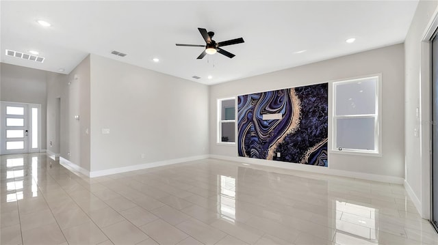 empty room with visible vents, baseboards, and ceiling fan