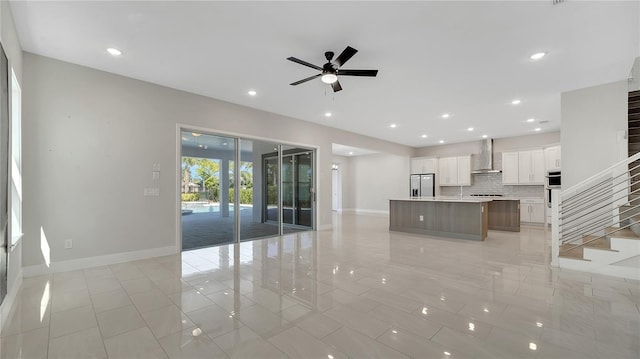 unfurnished living room with recessed lighting, stairway, baseboards, and a ceiling fan