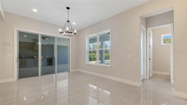 spare room with an inviting chandelier, light tile patterned flooring, recessed lighting, and baseboards