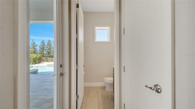 bathroom with tile patterned flooring, toilet, and baseboards