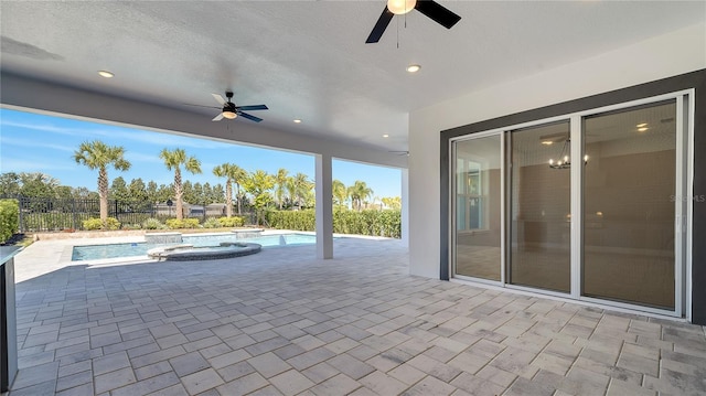 view of pool with a patio, a ceiling fan, fence, and a pool with connected hot tub