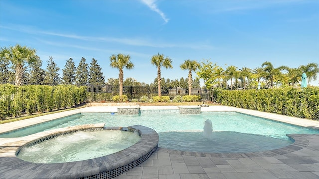 view of pool featuring a pool with connected hot tub and fence