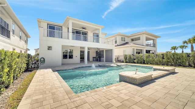 rear view of property featuring stucco siding, a fenced backyard, a balcony, a patio area, and a ceiling fan