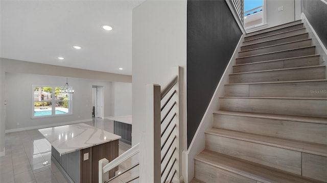 stairway featuring a chandelier, tile patterned flooring, recessed lighting, and baseboards