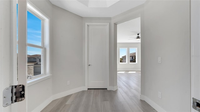 unfurnished room with baseboards, light wood-style floors, and ceiling fan