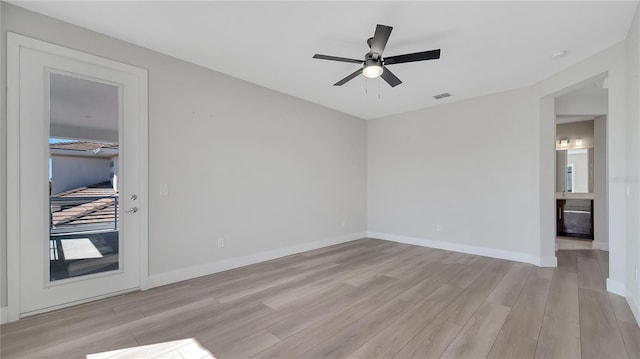 empty room with ceiling fan, visible vents, baseboards, and light wood-style flooring