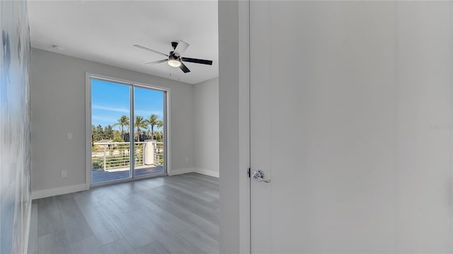 unfurnished room featuring baseboards, wood finished floors, and a ceiling fan