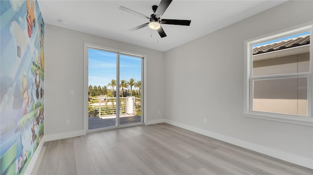 spare room with a ceiling fan, wood finished floors, and baseboards