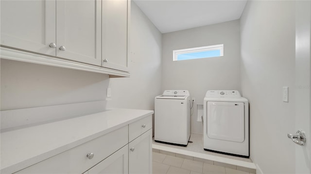 clothes washing area with washing machine and clothes dryer and cabinet space