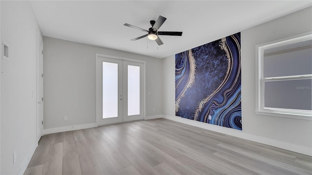 spare room with french doors, baseboards, a ceiling fan, and wood finished floors