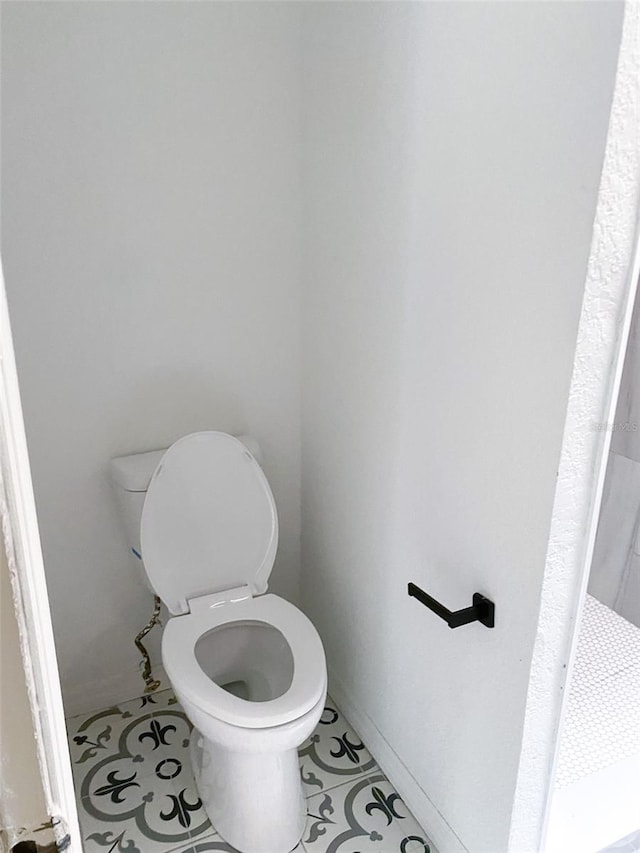 bathroom featuring baseboards, toilet, and tile patterned floors