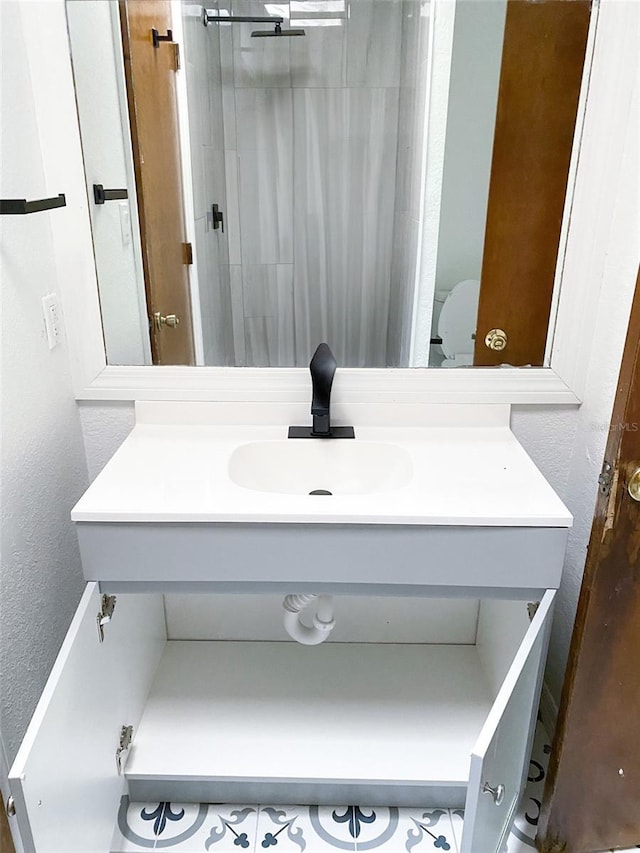 bathroom with a textured wall and vanity