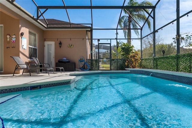 pool featuring glass enclosure, a patio area, and fence