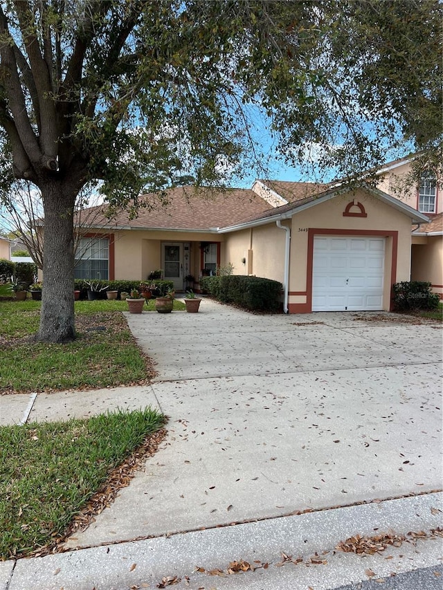 single story home with driveway, a garage, and stucco siding