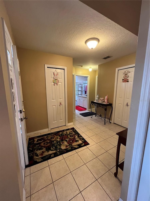 3449 Village Green Ct, Saint Cloud, FL 34772 - foyer featuring visible vents, a textured ceiling, baseboards, and light tile patterned floors