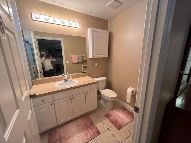 3449 Village Green Ct, Saint Cloud, FL 34772 - bathroom featuring a textured ceiling, tile patterned flooring, toilet, vanity, and visible vents