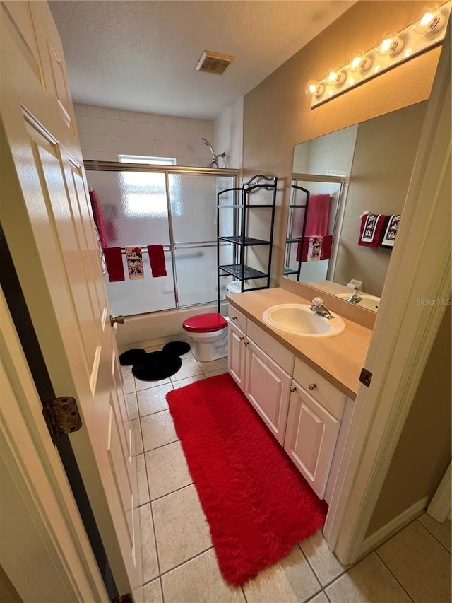 3449 Village Green Ct, Saint Cloud, FL 34772 - bathroom with a textured ceiling, tile patterned flooring, toilet, bath / shower combo with glass door, and vanity