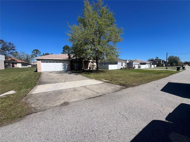 view of front facade featuring an attached garage, driveway, and a front lawn