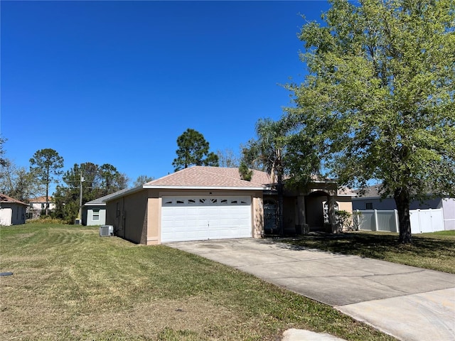 ranch-style house featuring fence, stucco siding, concrete driveway, a front lawn, and a garage