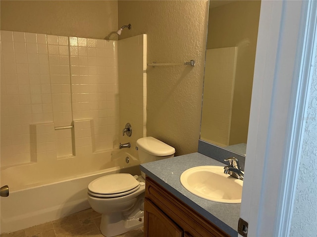 full bathroom with toilet, vanity,  shower combination, and a textured wall