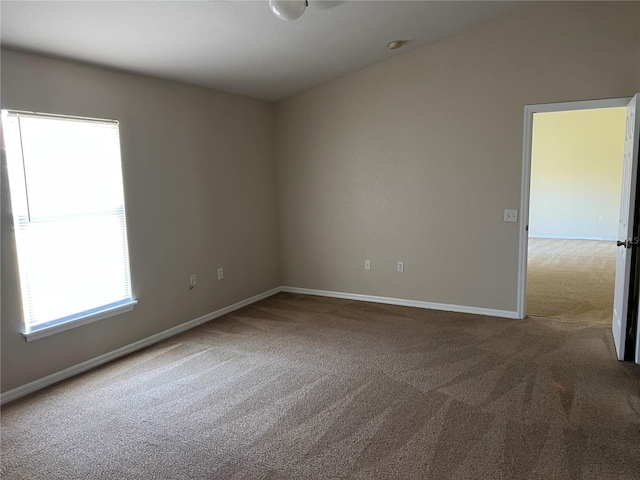 carpeted empty room featuring baseboards