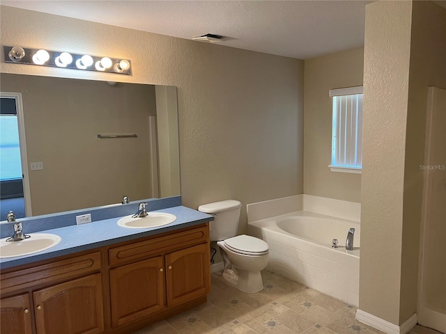 full bathroom featuring a bath, double vanity, toilet, and a sink