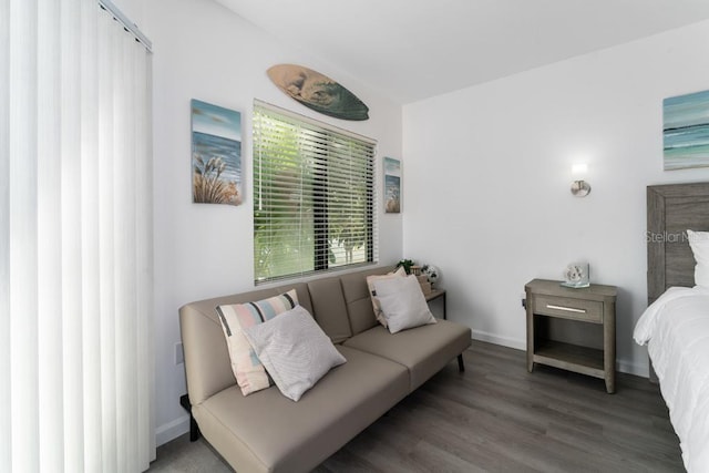 bedroom with dark wood-type flooring and baseboards