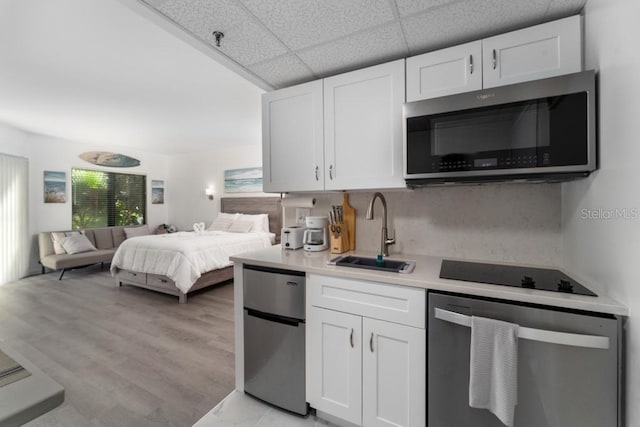 kitchen with white cabinetry, appliances with stainless steel finishes, open floor plan, and light countertops