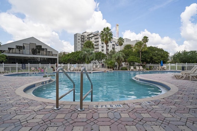 pool with fence and a patio