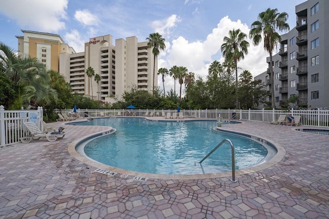 community pool with fence and a patio