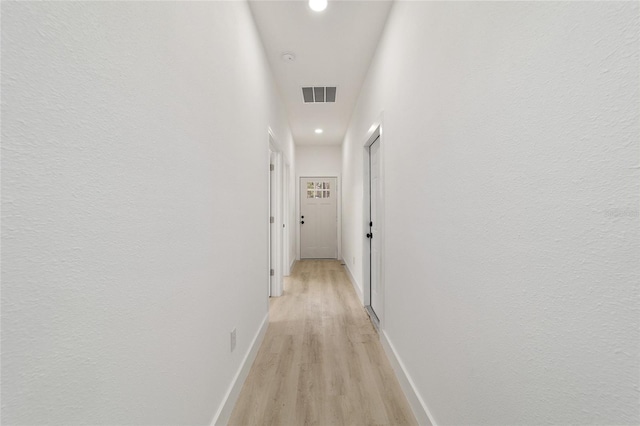 hall with light wood-type flooring, visible vents, baseboards, and recessed lighting