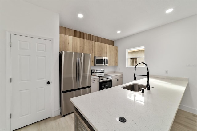 kitchen featuring a sink, appliances with stainless steel finishes, a peninsula, and recessed lighting