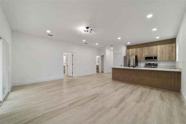 kitchen with open floor plan, recessed lighting, and stainless steel appliances