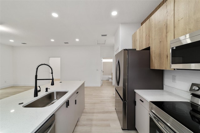 kitchen featuring a sink, recessed lighting, modern cabinets, and stainless steel appliances