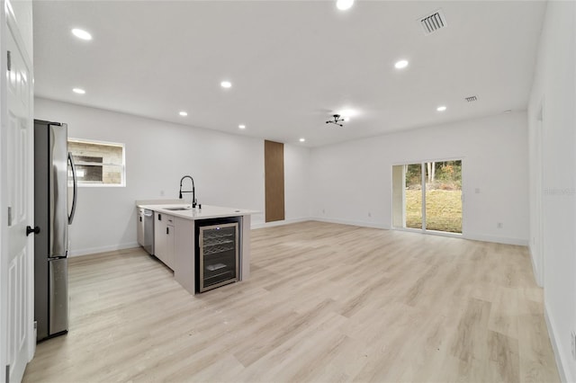 kitchen with beverage cooler, visible vents, recessed lighting, stainless steel appliances, and light wood-style floors