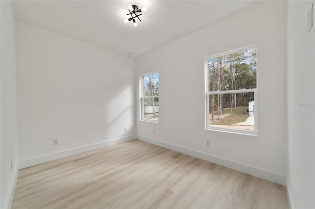 empty room with baseboards and wood finished floors