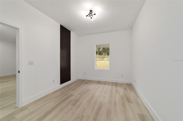 interior space with baseboards, a textured ceiling, and light wood-style flooring