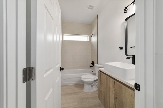 full bath featuring visible vents, toilet, wood finished floors, vanity, and shower / bathtub combination