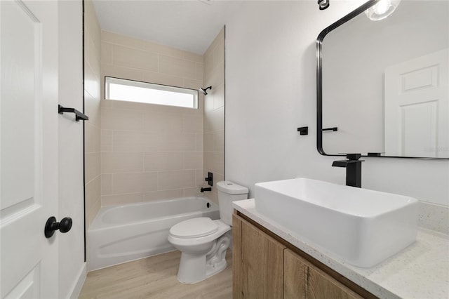 full bathroom with toilet, wood finished floors, vanity, and shower / tub combination