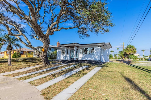 view of front of house with a chimney and a front yard