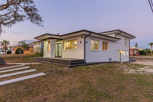 view of front facade featuring a lawn and stucco siding