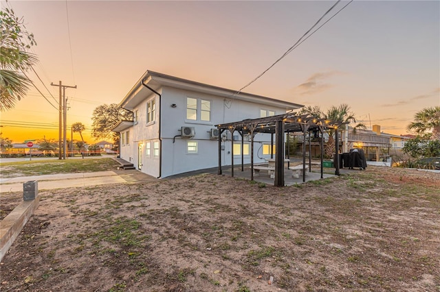 rear view of house featuring stucco siding, a patio, fence, and a pergola