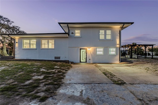 tri-level home with a pergola and stucco siding